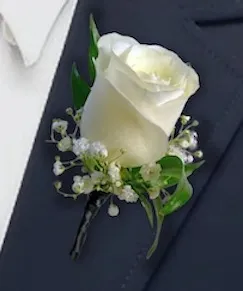 White rose boutonnière with baby's breath pinned on a navy lapel